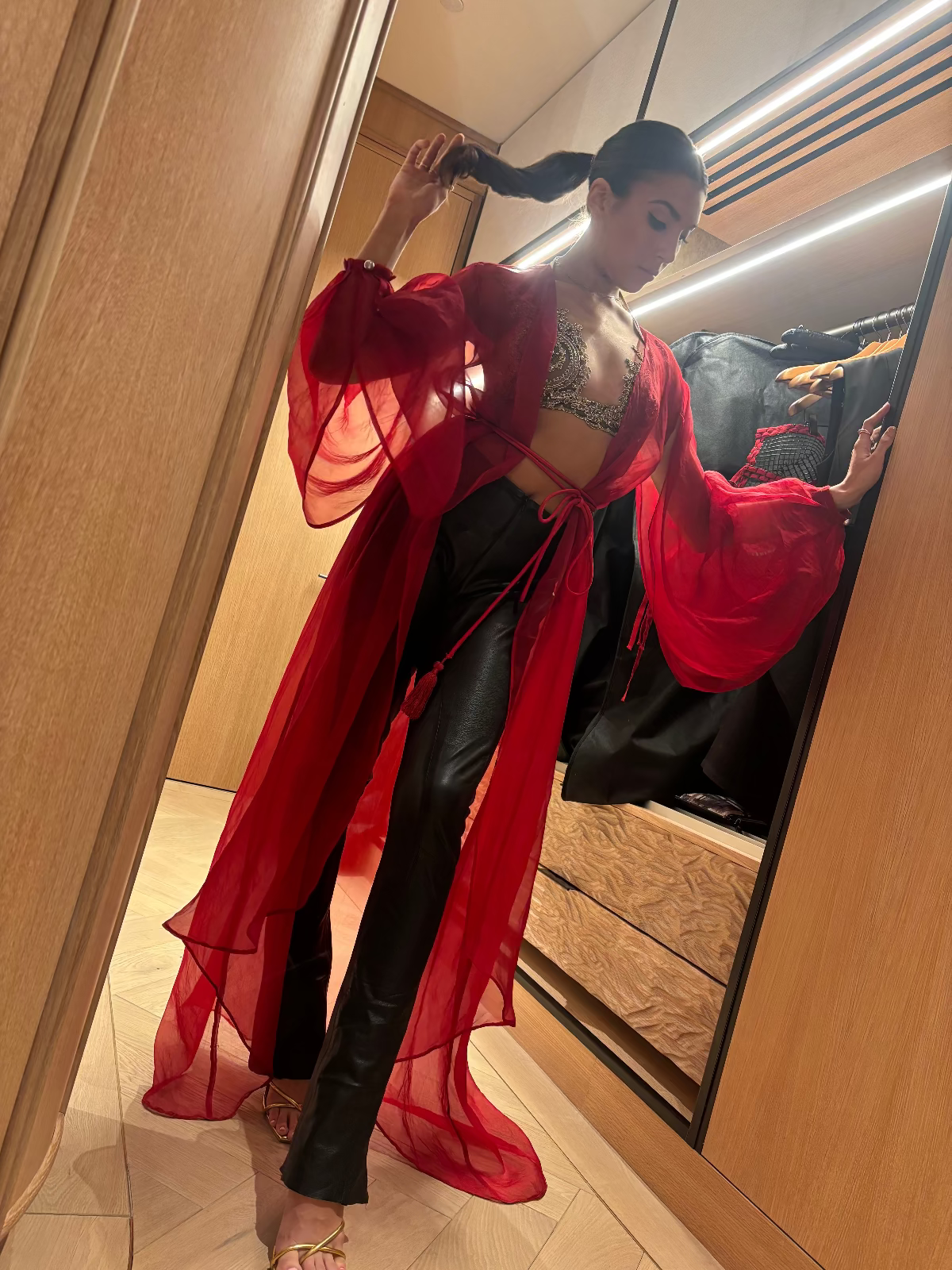 Fashion model wearing a Priscilla Couture red robe with black leather pants