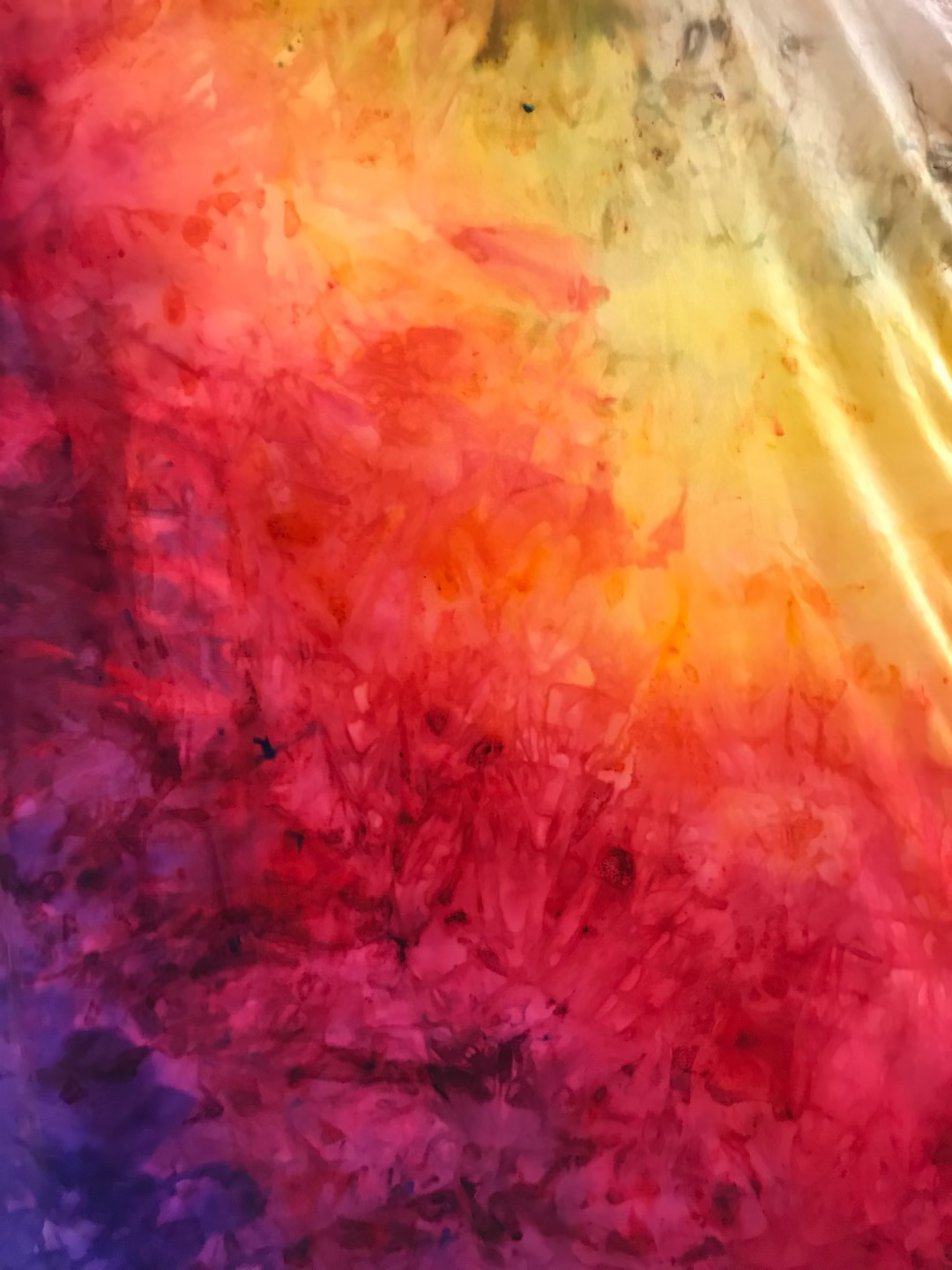 Multicolored textured fabric with a gradient of red, orange, yellow, green, blue, and purple.