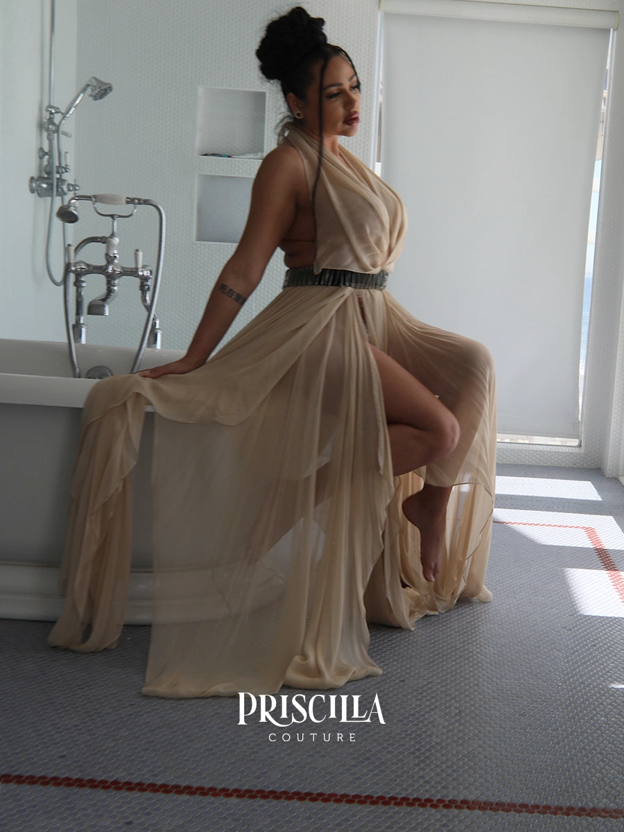 A woman models a Priscilla Couture champagne beige draped convertible skirt with a wide black belt, posing in a modern bathroom setting.