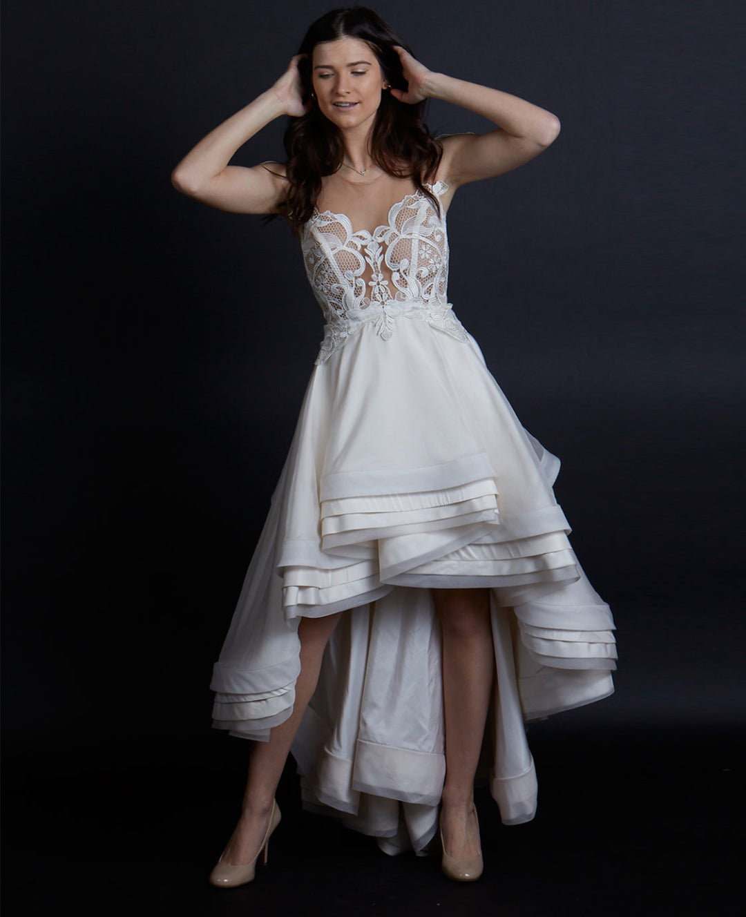 Model wearing a Priscilla Couture wedding dress over a dark background.