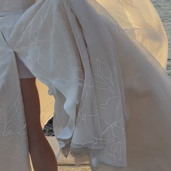 NYC bride in her Priscilla Couture custom wedding gown with her groom walking by the river. NYC skyline clear in the background.