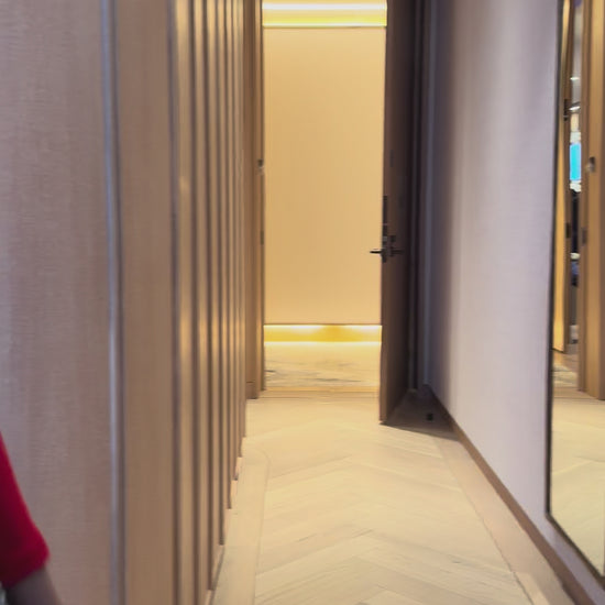 Priscilla Couture fashion model in a grey floral bridal skirt walking a hallway.