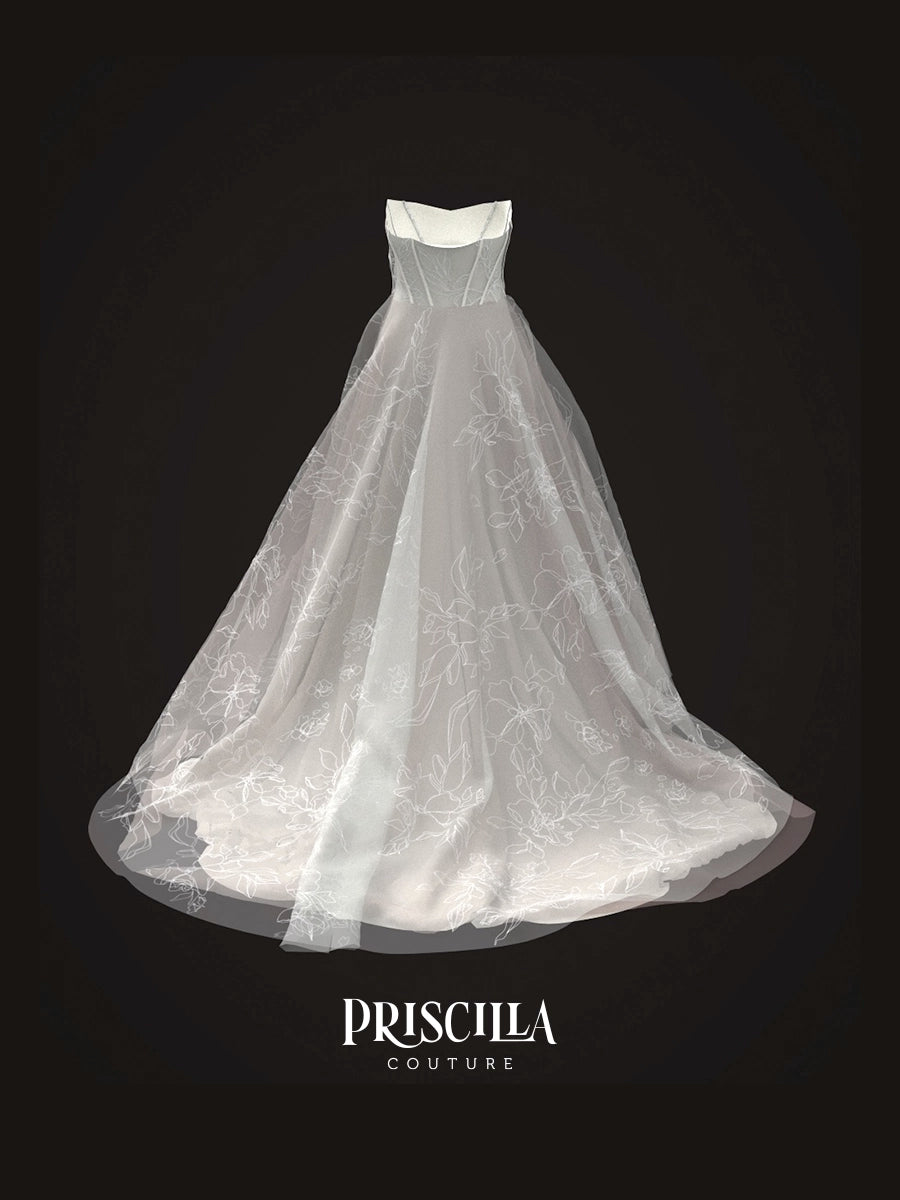 A 3D avatar of a Priscilla Couture custom white strapless A-line wedding gown with a sheer tulle overskirt and delicate floral lace pattern, displayed against a solid black background with the brand name 'PRISCILLA COUTURE' at the bottom.
